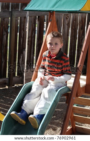 Young blond boy playing on the garden play-set