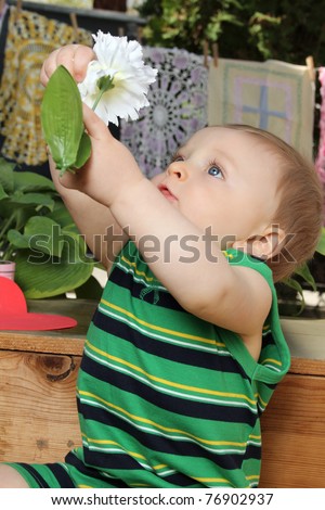 Cute baby boy outside in the garden wearing green outfit