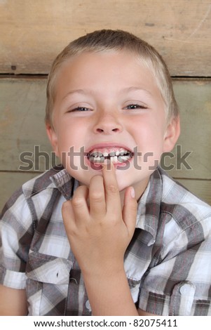 Cute blond boy showing his missing tooth