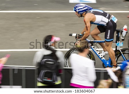MELBOURNE, VICTORIA, AUSTRALIA - MARCH 23, 2014 - Nigel Cooper of Australia passes spectators on the 180km Ironman bike leg on March 23, 2014.