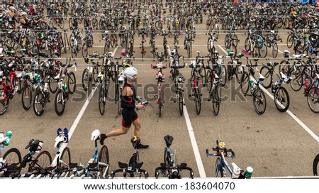 MELBOURNE, VICTORIA, AUSTRALIA - MARCH 23, 2014 - An unidentified Elite male athlete runs through the bike compound during tranisition at the Ironman on March 23, 2014.
