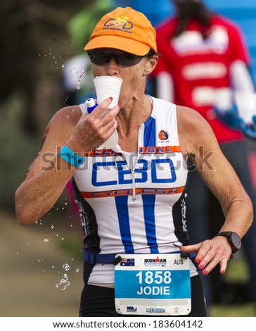 MELBOURNE, VICTORIA, AUSTRALIA - MARCH 23, 2014 - Jodie Morris  of Australia passes through an Aid Station during the Ironman run leg on March 23, 2014.