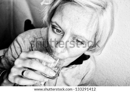 Women drinking short drink and thinking - black and white
