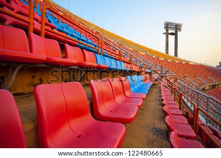 curve seats, red and blue stadium seats rows on stadium with spot light pole