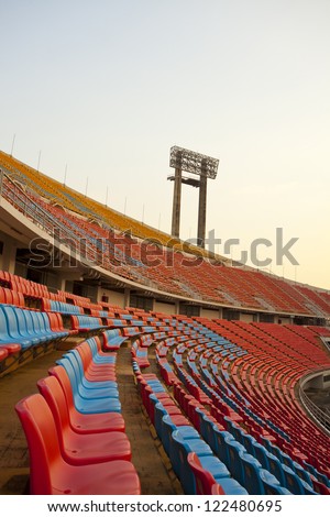 stadium seats, red and blue stadium seats curve rows on stadium with spot light pole