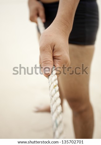 pulling rope, male pulling big rope with two hands