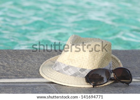 sunglasses and hat, black sunglasses and white weave hat with pool background