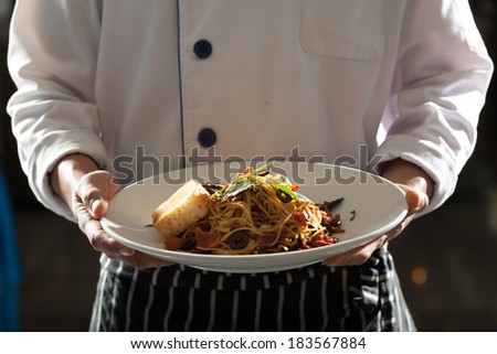 Spaghetti, Male model in chef uniform holding a dish of seafood spaghetti