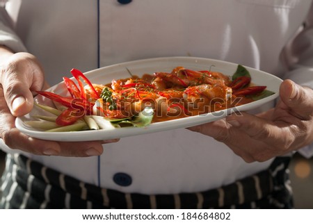 Thai dish, male model wear chef uniform holding Thai dish of shrimp spicy coconut milk