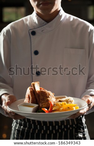 german pork, Male model in chef uniform holding a dish of german pork leg