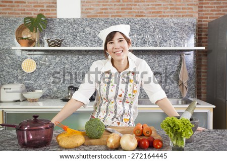 Woman Chef, An Asian woman chef pose showing cooking in the kitchen