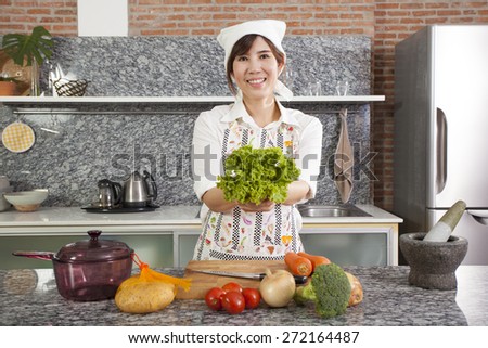 Woman Chef, An Asian woman chef pose showing cooking in the kitchen