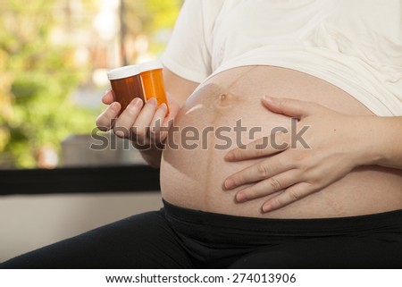 pregnancy care, Asian pregnant woman shows medicines vitamin pills in her hand