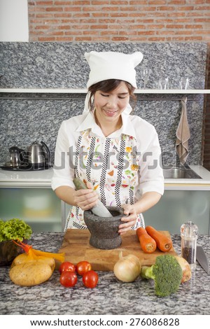 chef with mortar, An Asian woman chef smiling cooking with Thai mortar in the kitchen