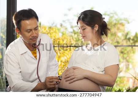 Pregnancy check, a male doctor using stethoscope check on pregnant woman