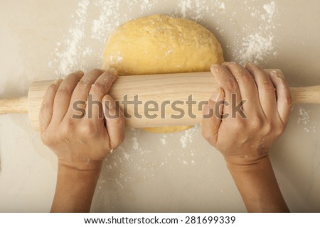 Pasta Homemade, a female hand rolling flour making pasta homemade