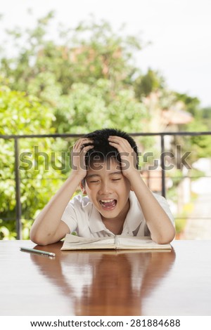 headache boy, an Asian young boy squeeze his head for homework like crazy