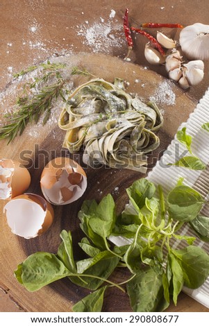 Fresh Pasta Raw spinach fresh pasta tagliatelle decor with fresh spinach on background