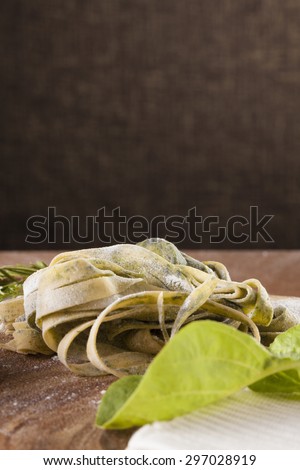 Fresh Pasta Raw spinach fresh pasta tagliatelle decor with fresh spinach on background