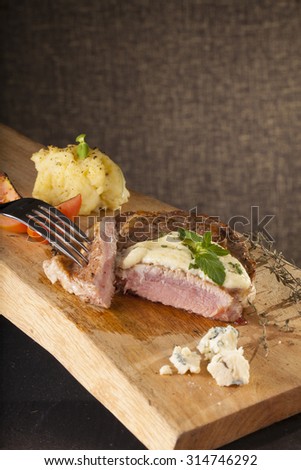 steak, a prepared piece of steak cut with blue cheese sauce on dining table decorated