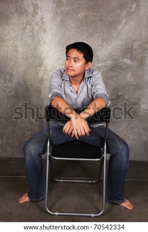 a man sits on a chair ,