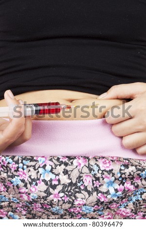 insulin injection. Female model injecting insulin cure on stomach.