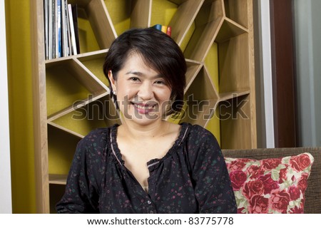 nice woman, asian woman having a nice smile in front of bookshelf.