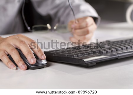 click, male model hand clicking a mouse and holding glasses.