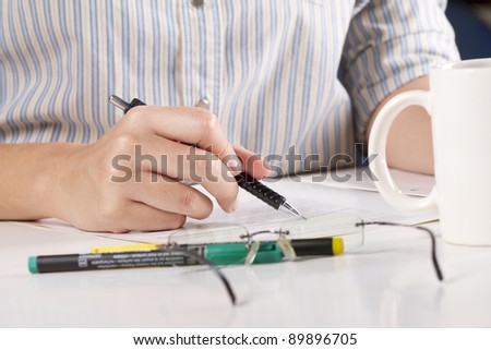 working time, female officer using pencil to analyse words in a book.