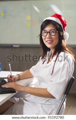 Female Santa doctor, Asian Santa doctor wearing white gown smiling.