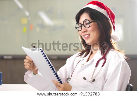 Doctor reading report, Santa female doctor reading book smiling.