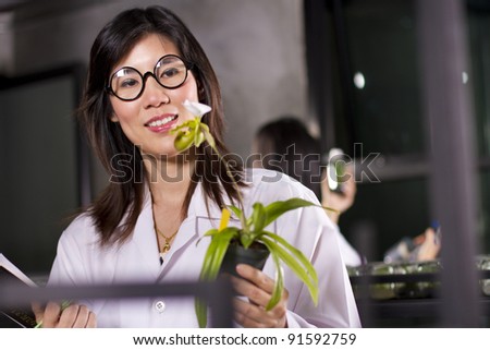 Orchid growing, two scientists working in lab about growing plant.