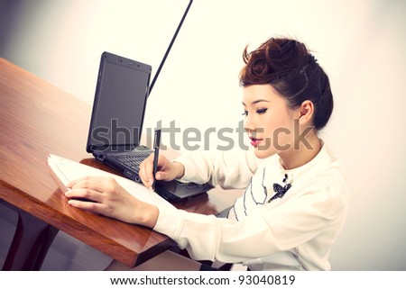 office, female officer busy working with laptop and notebook.