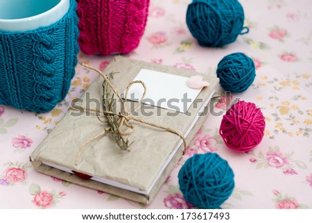 Two blue cups in blue and pink sweater with ball