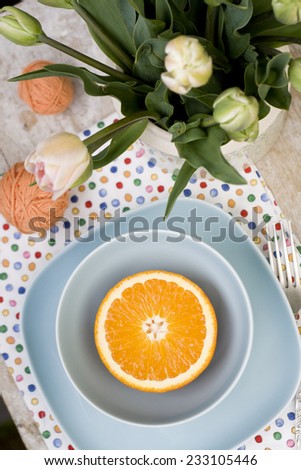 Juicy orange on blue plate is the old pad and tangles of yarn