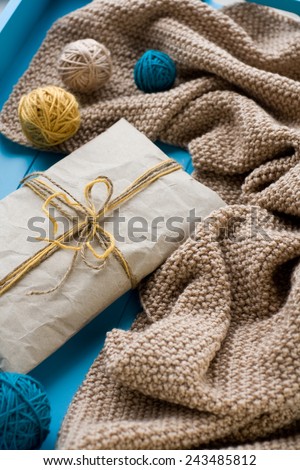 A gift to lie next to the coil bright filaments and blanket knitted on blue background