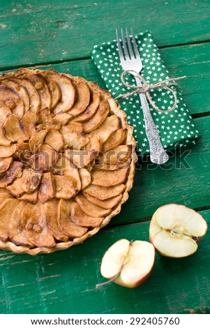 Juicy apple pie with cinnamon and brandy on a green background
