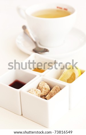 Cup of tea with lemon, sugar, honey and jam