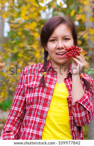 Girl holding a bunch of red berries of arrow wood