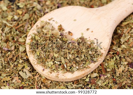 Pile of ground dried Basil (Sweet Basil) as background with wooden spoon. Used as a spice in culinary herb all over the world. The plant is also used in medicine.