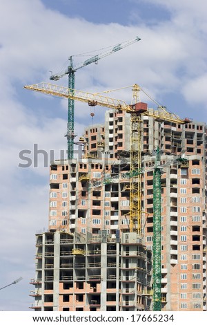 Construction site of modern highrise building with cranes in operation