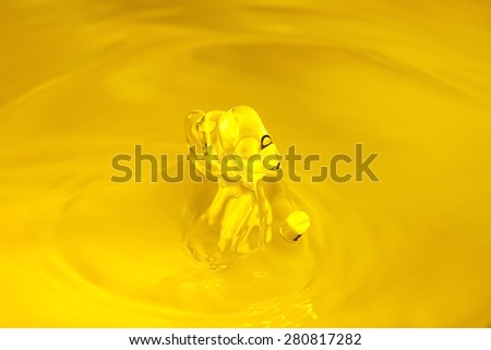 Dripping yellow gold water drop closup.
