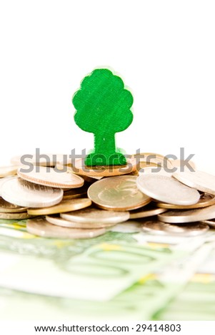 Ecology concept, a toy tree on a pile of money