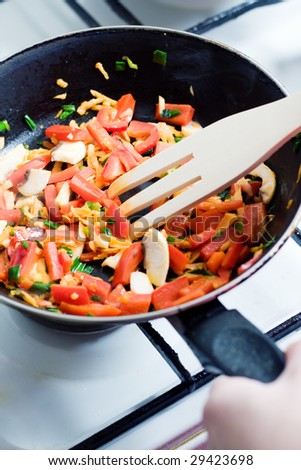 Cooking - peppers with carrot, mushrooms and onion in a pan