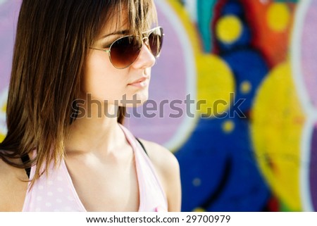 Teenage with different accessories, with a graffiti background, fashion look