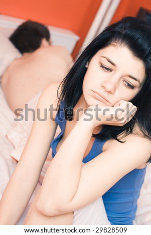Problems of a unhappy young couple in bedroom, focus on female