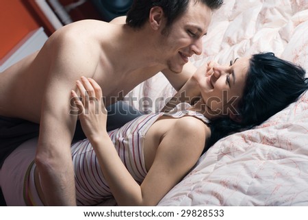 Man and women cuddling together on a bed