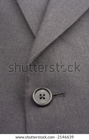 Up close of suit coat button and lines.