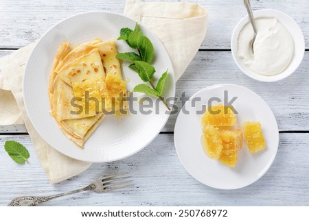 Sweet pancakes with honey on a plate, dessert. Top view