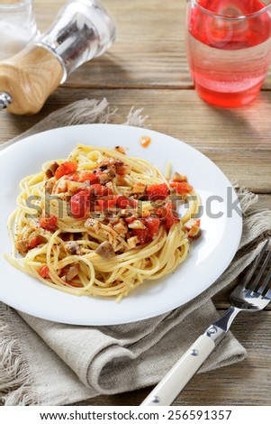 Pasta with tomatoes and mushrooms on a white plate. Traditional italian food